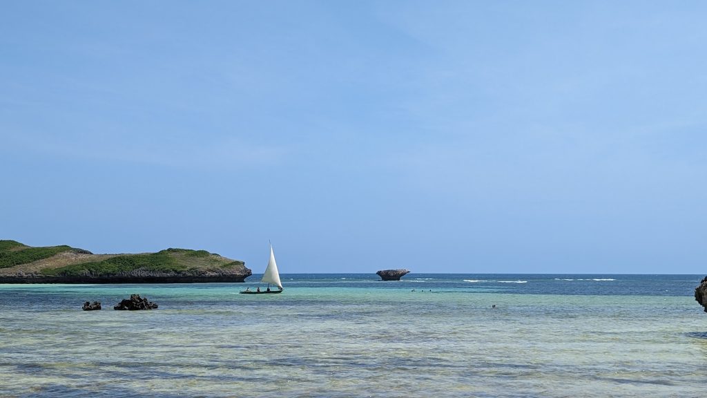 Blue hues in Watamu Kenya with a traditional fishing boat and small islets